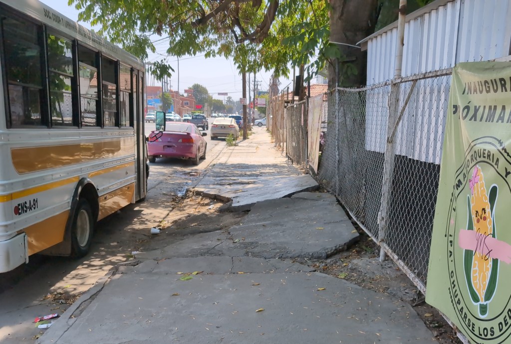 Slabs of broken sidewalk just up a foot and a half  into to the air. Beside it is a missing section, making the entire sidewalk with a hazard.